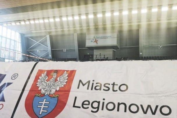 Zdjęcie oświetlenia wewątrz Areny Legionowo. Na pierwszym planie grafika z napisem Miasto Legionowo