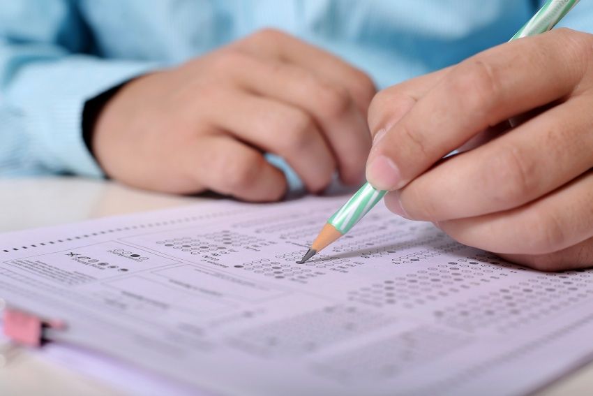 Na zdjęciu uczeń wypełniający kartę egzaminacyjną