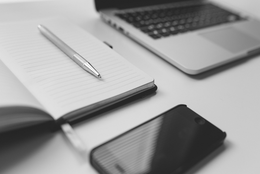 Na zdjęciu notes, smartphone i laptop