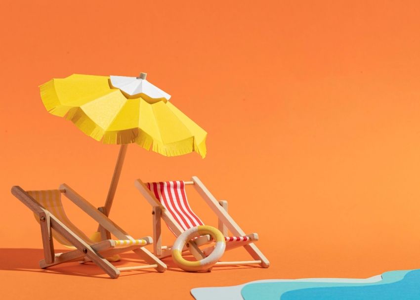 Na zdjęciu leżaki, parasol oraz piasek