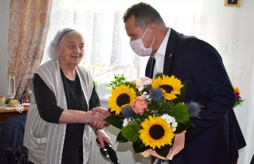 Prezydent miasta wręcza bukiet kwiatów jubilatce