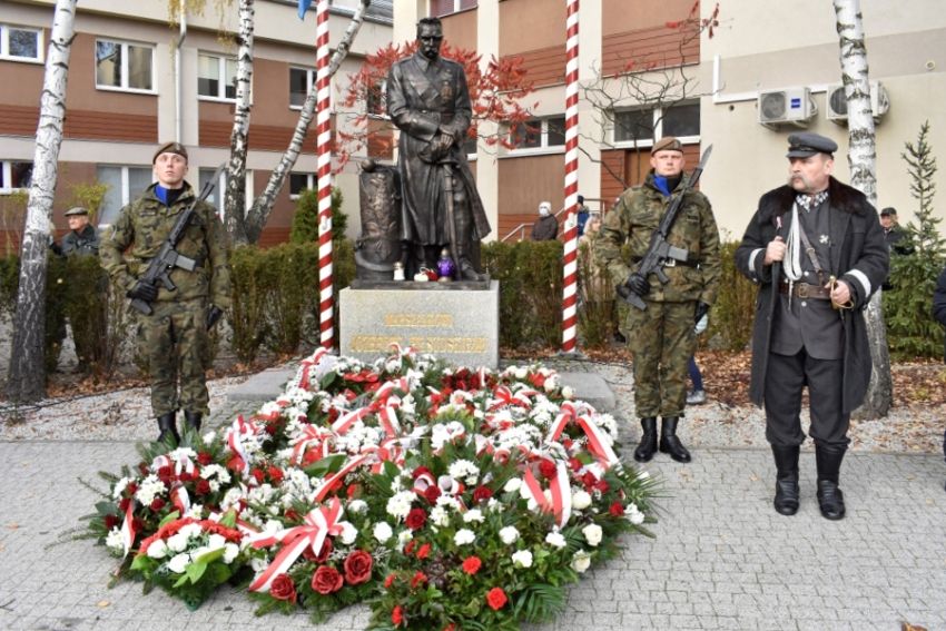 Wiązanki pod pomnikiem Piłsudskiego, obok dwóch stojących żołnieży i mężczyzna przebrany za marszałka