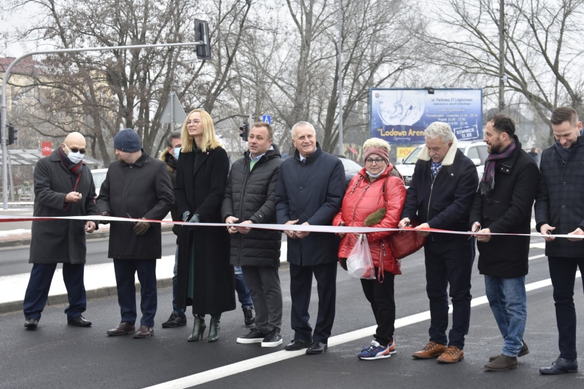 Kilka osób w rzędzie przecinający wstęgę otwarając ulicę