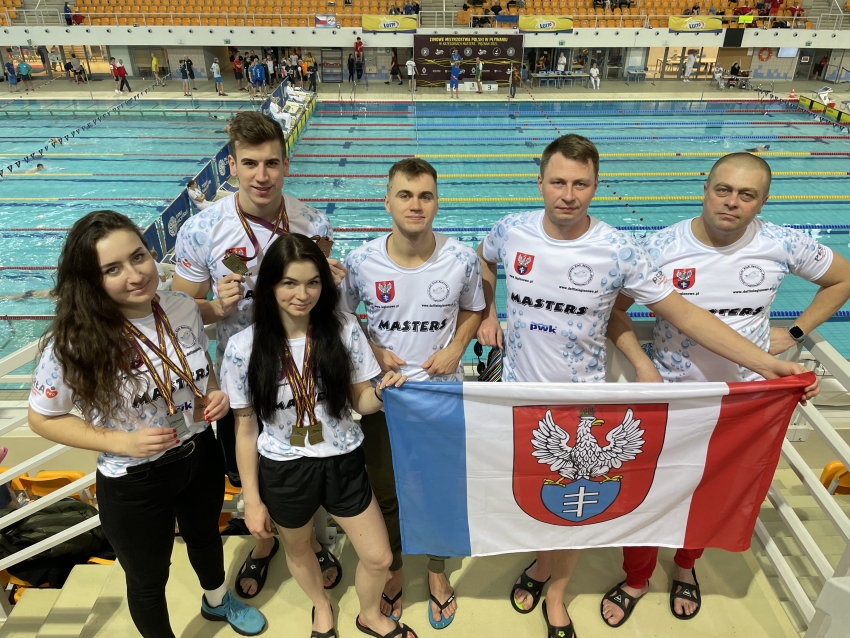Zespół UKS Delfin z flagą Legionowa na basenie