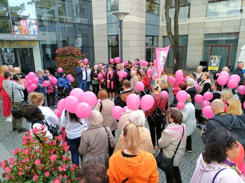 Zgromadzenie osób podczas marszu różowej wstążki, ludzie trzymają w rękach różowe balony