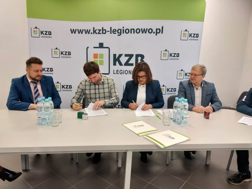 Grupa osób siedzi przy stole. Podpisanie umowy.