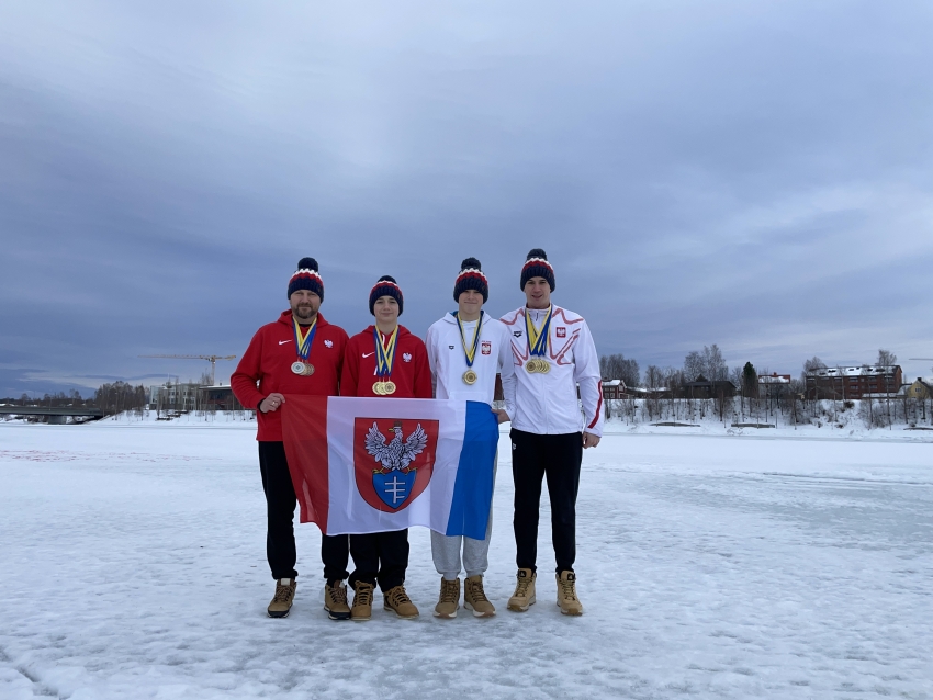 Czterech mężczyzn z flagą Legionowa na śniegu