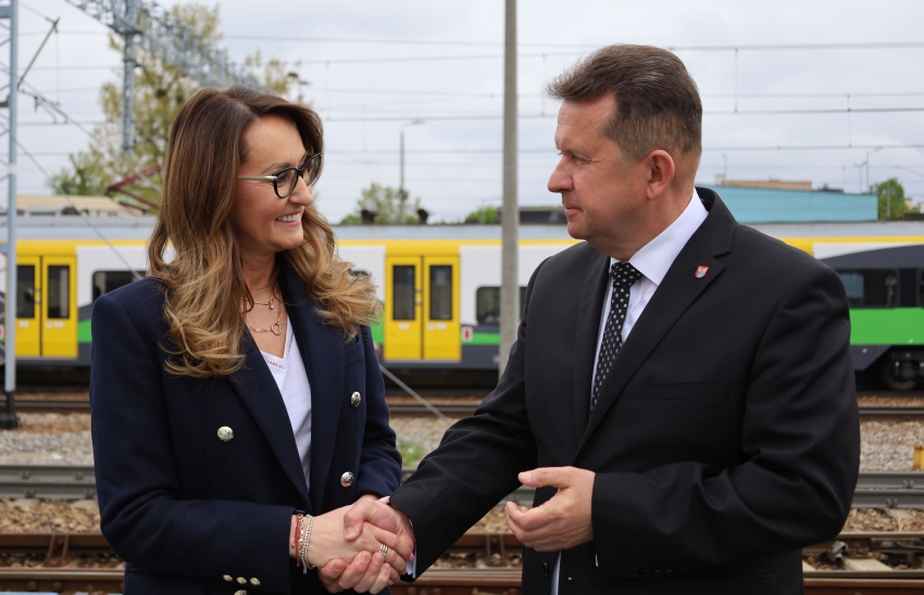 Na zdjęciu dwie osoby na tle pociągu