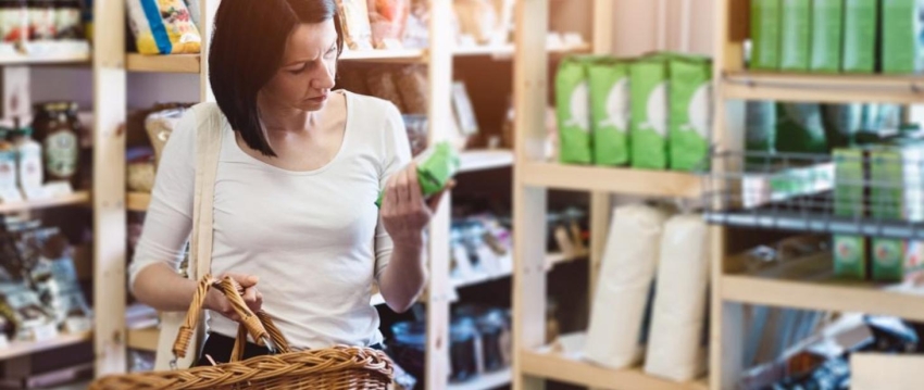 Kobieta czytająca etykietę produktu, który trzyma w rękach